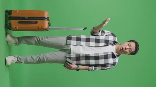 Wondering Male Traveler With Luggage Holding Passport And Doubtfully In The Green Screen