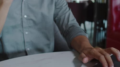 Man Answers Phone While Using Laptop at Desk