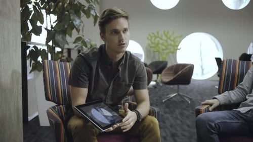 Colleagues Meeting in Casual Office Discussing Charts