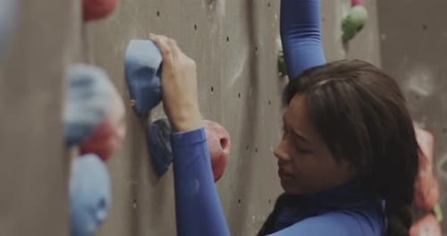Woman Ascends Rock Climbing Wall With Determination