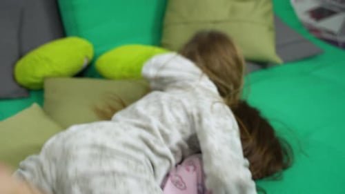 Two Little Girls Fighting for Fun on Sofa