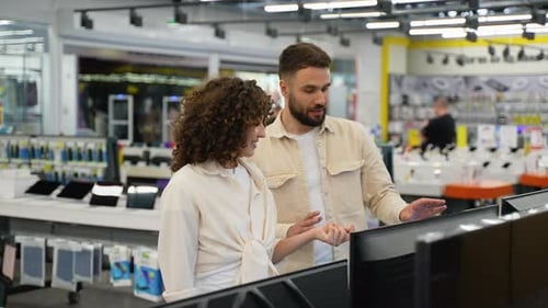 Newlyweds Couple Choosing Tv in Electronics Store