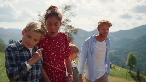 Relaxed Family Rest Walking Beautiful Mountain Meadow Sunny Day. Smiling Parents Speaking
