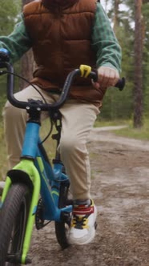 Child Riding Bicycle on Forest Path Vertical Outdoor Lifestyle Video