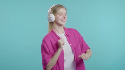 Active Happy Woman Listens Music Dancing with Headphones on Blue Studio Radio