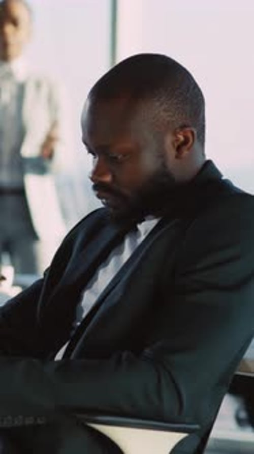 A Businessman in a Suit Sits Contemplatively Reflecting on Decisions