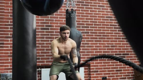 Men with Combat Rope Exercise in the Fitness Gym
