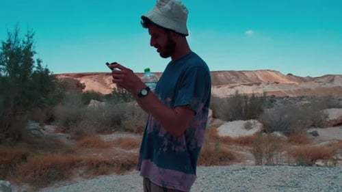 Slow Motion Arcing Shot of White Man on Phone in Middle of Desert