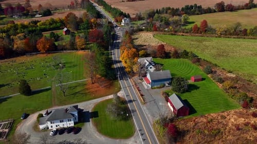 An aerial view over a two-lane road in a rural area of New Jersey with expansive farmland and large