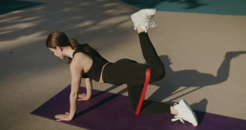 Woman Doing Resistance Band Glute Workout Outdoors