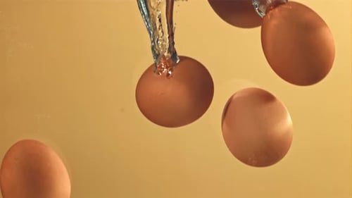 Eier fallen mit Blasen unter Wasser, gefilmt mit einer Hochgeschwindigkeitskamera mit 1000 Bildern pro Sekunde