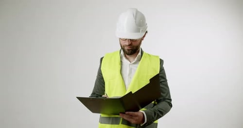 Construction Supervisor Reviews Plans on Clipboard in Studio