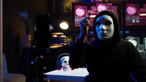 Un membre d'un groupe de hackers portant un masque anonyme filme une Vidéo menaçant le gouvernement