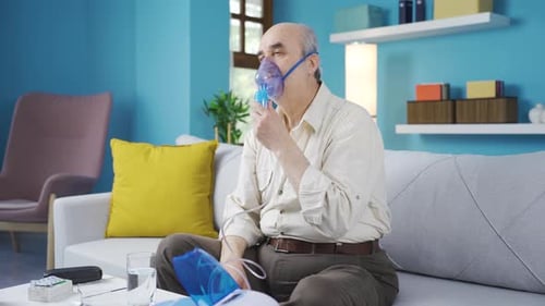 Un vieil homme malade a des problèmes respiratoires et utilise un respirateur.