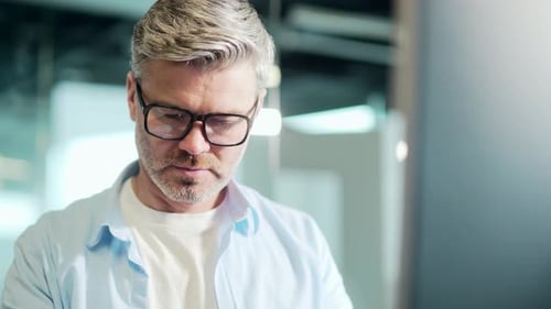 Man Wearing Glasses Concentrating at Computer Screen