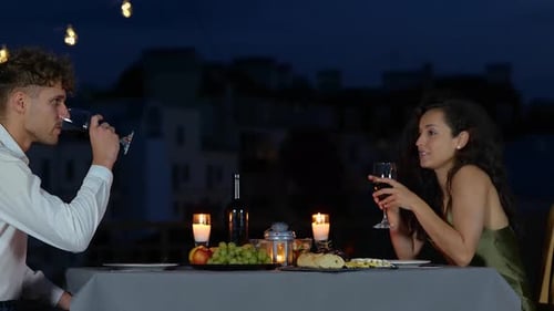 Happy Man and Woman Holding Glasses with Wine While Having Date Talking on the Terrace in the