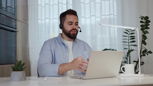 Man Using Laptop for Video Conference Call at Home