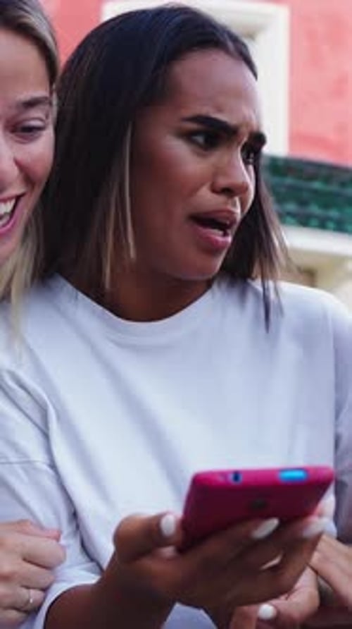 Three Happy Smiling Female Friends Looking at the Screen Using Mobile Smart Phone