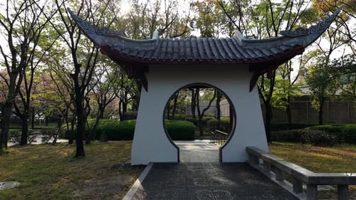 Traditional Asian Garden Gate with Curved Roof in Park
