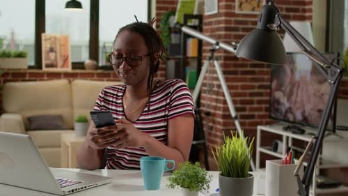 Woman Uses Phone at Desk in Home Office