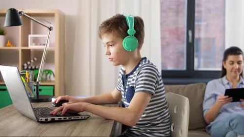 Konzept für Kinder, Bildung und Fernunterricht - Student Boy mit Kopfhörern und Laptop-Computer...