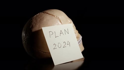 Skull with 'Plan 2024' Note in Dramatic Light