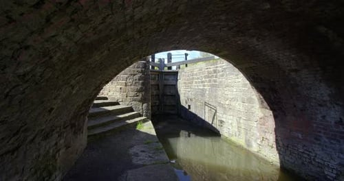Shot under the arch of a humpback bridge over the Chesterfield Canal at Stret lock with lock in back