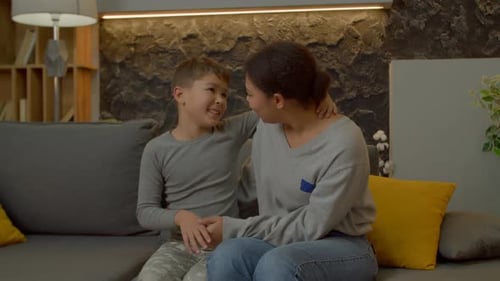 Woman and Child Sitting Together on Sofa