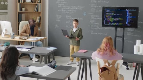 Junge hält vor der Klasse einen Vortrag über Programmieren