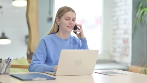 Young Adult Woman on Phone While Working
