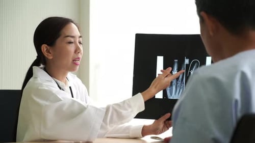 Doctor Examining X-Ray with Patient in Hospital