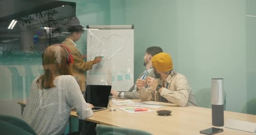 Professionals Collaborate on Strategy at Meeting Room Whiteboard