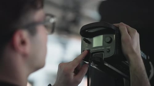 Technician Pressing Power Switch on LED Studio Light During Broadcast Shoot