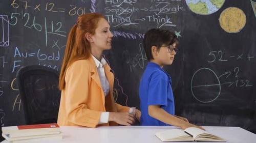 Friendly Teacher Helps Boy at Desk