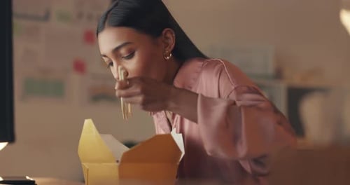 Fast food and eating with a business woman enjoying a takeaway meal while working late in her office