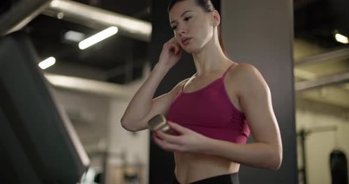 A Young Beautiful Brunette Girl in Sportswear Exercises on a Simulator in the Gym Doing Cardio
