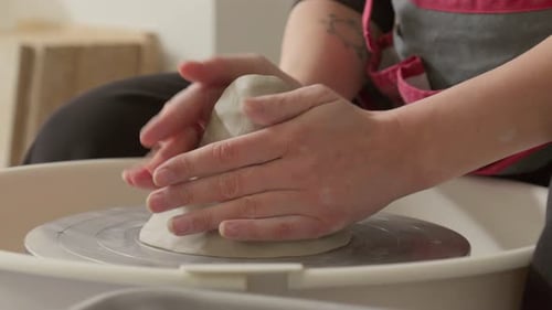 Close up of hands shaping clay on pottery wheel