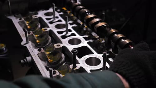 Mechanics install camshaft in cylinder head Engine repair and parts installation