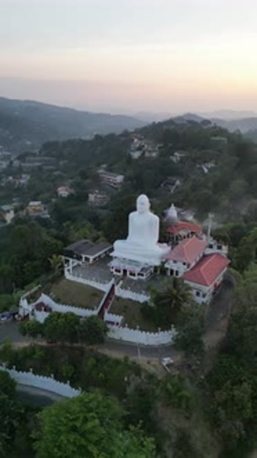 Drone photo d'un grand Bouddha blanc assis surplombant les collines verdoyantes environnantes