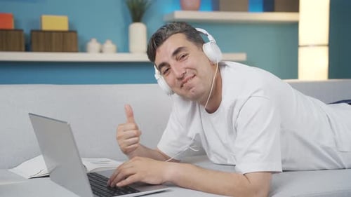 Man Lays on Couch Typing on Laptop