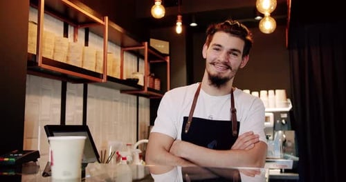 Smiling Barista Gives Thumbs Up in Coffee Shop