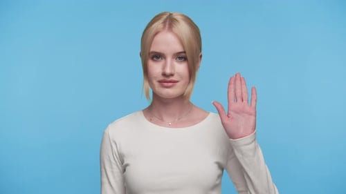 Young Adult Waving Her Hand on Blue Backdrop