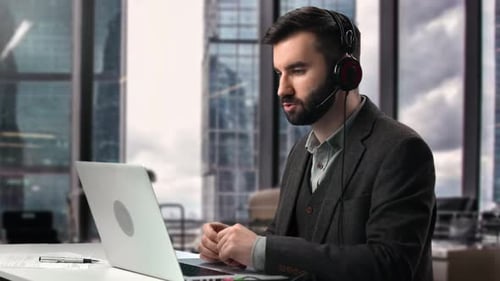 Business Man Talking Headset Work with Customer Remotely Communication Use Laptop Skyscraper Office