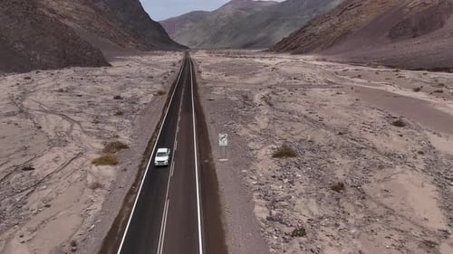 Highway in Desert Valley with Mountains Offers Scenic Landscape for Adventurous Journey