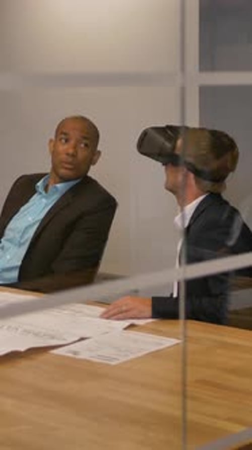 Vertical of Male in VR Headset Looking at Objects in Virtual Reality with Colleagues