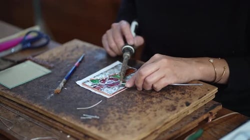 A woman making a stained glass work