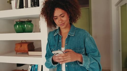 Woman Using Phone Indoors at Home by Bookshelf