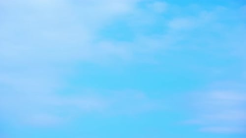 Puffy Clouds Drifting Across Pale Blue Sky