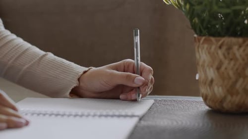 Close Up Shot of Unrecognizable Lefthanded Woman Writing in Copy Book Studying at Home Free Space