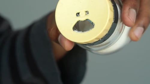 Persona sostiene un salero azul con cara triste